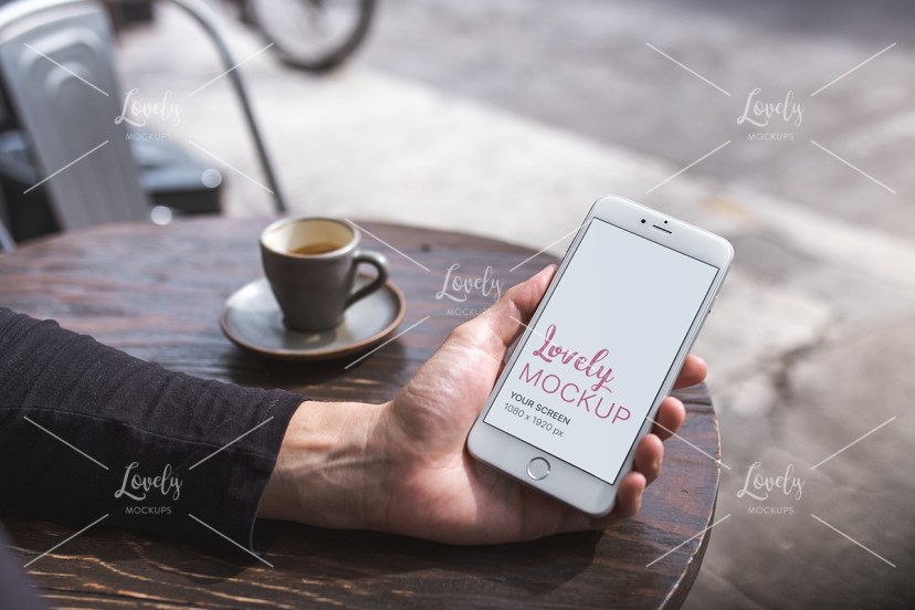 mockup of an iphone being held at a coffee shop